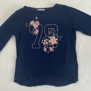 Stickad tröja med tryck - En skön stickad tröja med tryck som säger 78 med blommor runt om. Dock har blommorna och siffrorna försvunnit lite som man kan se i sista bilden. 