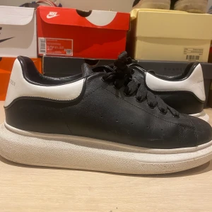 Alexander McQueen - Svart vita Alexander mcqueens i storlek 44, dom är i bra skick bara att det är en repa på baksidan av skon, annars ett par sköna skor som är bra till sommaren,  pris kan diskuteras