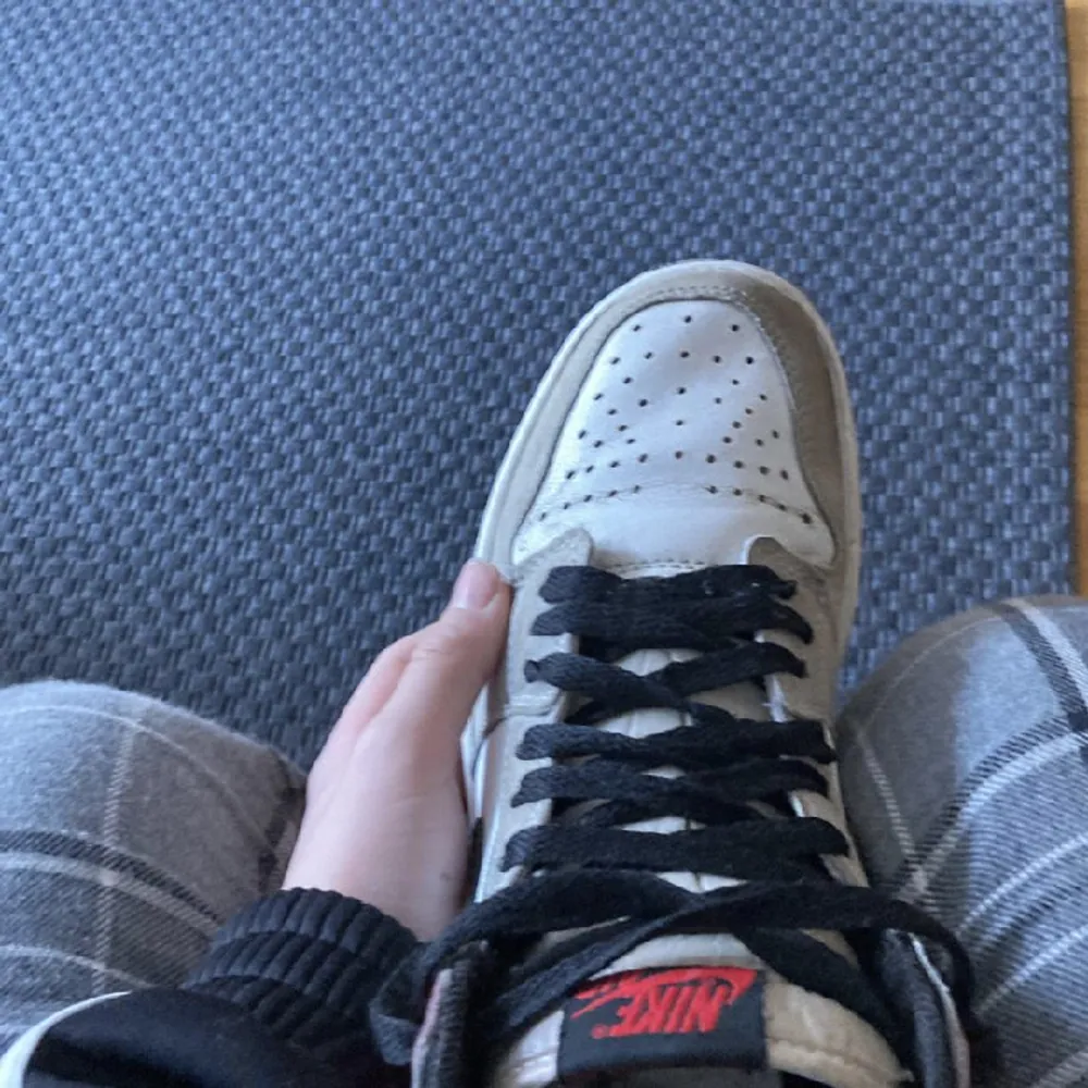 Ett par gråa och röda Jordans. Dom är lite creasade . Skor.