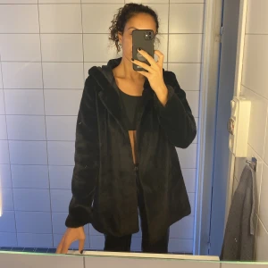 Fejk päls jacka från Yi Shang i storlek M - Fejk päls jacka från Yi Shang i storlek M. Sparsamt använd. Knäppt med en liten hake, se bild. Har luva och fickor på vardera sida