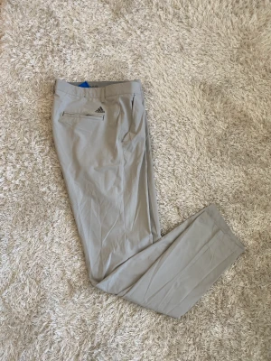 Adidas golfbyxor - Snygga Adidas golfbyxor i superskönt tunnt tyg som håller vid och vatten borta. Mycket fint skick. Ljusgrå. Strl 32/34