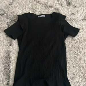 Zara topp  - Säljer den här jättefina t-shirten med volanger på axlarna från Zara!💕 storlek S men passar också XS! Köpt för 129kr💕 frakt = 63kr
