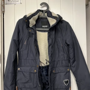 Marinblå ridjacka - Väldigt bra och praktisk ridjacka som jag nu har växt ut ur. Fortfarande bra skick. Jackan har fickor på väldigt många ställen. En på insidan och 6 på framsidan. På sidorna finns det även dragkedjor. Notera att man kan använda denna som vanlig jacka. 