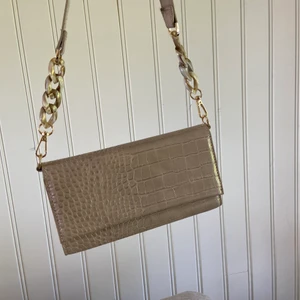 Handväska  - Helt oanvänd superfin väska från Åhléns i en beige/ljusrosa färg💞 Avtagbart axelrem, vilket gör att man kan byta om man så vill.  Inte superstor men perfekt om man bara ska ut en liten stund💕