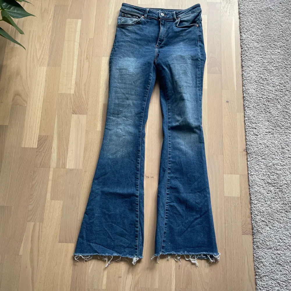Blåa lite ”blekta” utsvängda jeans från BikBok. Storlek M. Jeans & Byxor.