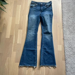 Blåa jeans från BikBok - Blåa lite ”blekta” utsvängda jeans från BikBok. Storlek M