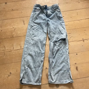 Blåa jeans - Blåa håliga jeans som har slits. Dom har blivit för små och jag har tröttnat på dom. Bara använt några få tal gånger och det är bra skick på dom.
