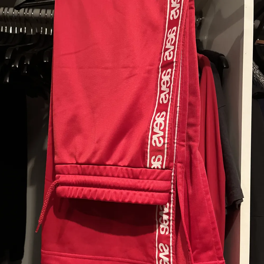Röd kjol från märket Svea, storlek M. Kjolen är ungefär vadlånga på mig som är 170cm, har slits på vardera sida och har snöre i midjan. Köparen står för frakten.. Kjolar.