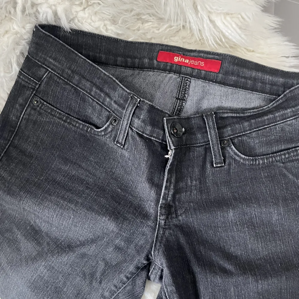 Mörkgrå lågmidjade utsvägnda jeans från Gina. Står ingen storlek men skulle säga att de passar 36-38. Köpt secondhand.. Jeans & Byxor.