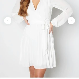 Studentklänning - superfin vit studentklänning med vida armar, v-ritning framtill och tunt tyg. Ett tygskärp finns som man kan knyta hur man vill eller inte anvönda alls. Använd 1gång 