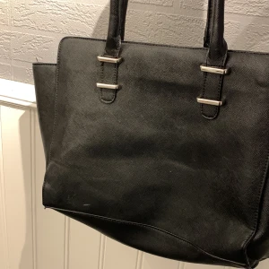 Väska  - Svart väska utan axelband, någon fläck därav priset 