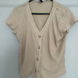 Beige button-up crop top for those hot summer nights. Size L but fits a size M/L