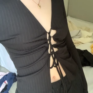 svart festtopp - svart festtopp med snörning i mitten från nelly! storlek XS. i nyskick då den aldrig är använd. köparen står för frakten som ingår i annonspriset (66kr).