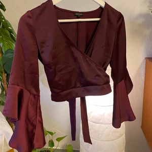 Partytopp  - Superfin magtröja med dramatiska ärmar och som man knyter i ryggen. Har en glansigt material. 