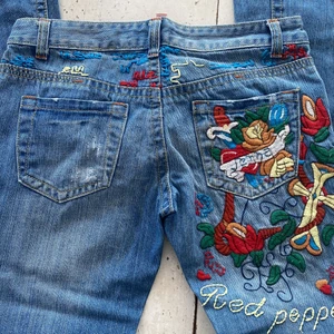 Lågmidjade jeans med tryck - SJUKT SNYGGA lågmidjade but cut jeans med unikt tryck i storlek 25. Har inga bilder med passform eftersom att dom inte passar mig. Köparen står för frakt. Kontakta för mer information 💗 midjemått=76cm Innerbenslängden=79cm ytterbenslängd=95cm