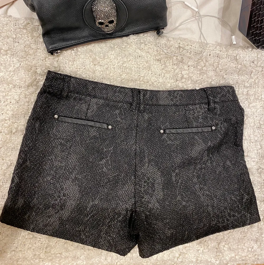 Väldigt trendiga och snygga relativt lågmidjade ”djur” skinns shorts med läder och nitar detaljer på sidorna. De är i storlek L men passar mig som är S i vanliga fall. Shorts.