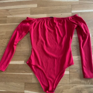 Ribbad röd body  - Ribbad röd body i storlek 40 men passar 38. Kan skickas om köparen betalar för frakten.