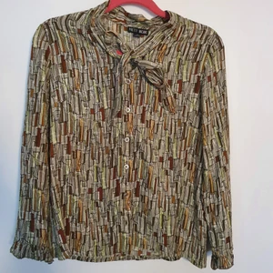 Knytblus med 60-talsmönster - Helt ny knytblus med 60-talsmönster. Knappar hela vägen samt volanger längst ned vid ärmen. Jag bjuder på frakten.