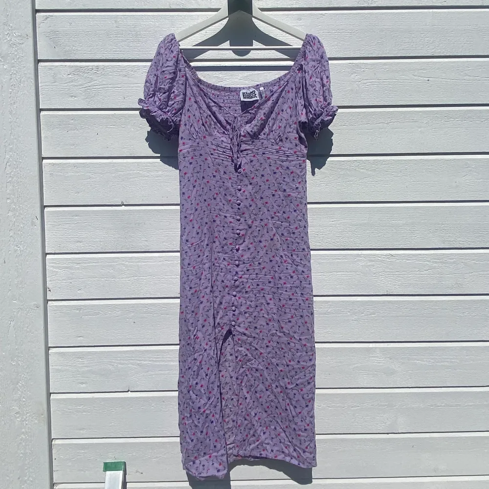 Jättefin lilablommig klänning från Reclaimed Vintage, köpt på Asos. Knytning där fram och slits i mitten. Använd fåtal gånger. Fint skick 😊. Klänningar.