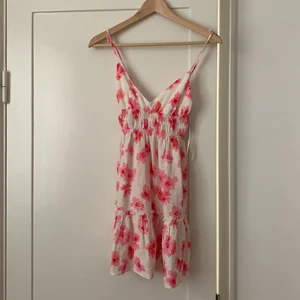 Pull & Bear miniklänning, XS/S - En blommig miniklänning från Pull & Bear. Nyskick då den aldrig använts. Står att det är storlek S, men den är en aning kort så den skulle även kunna passa XS