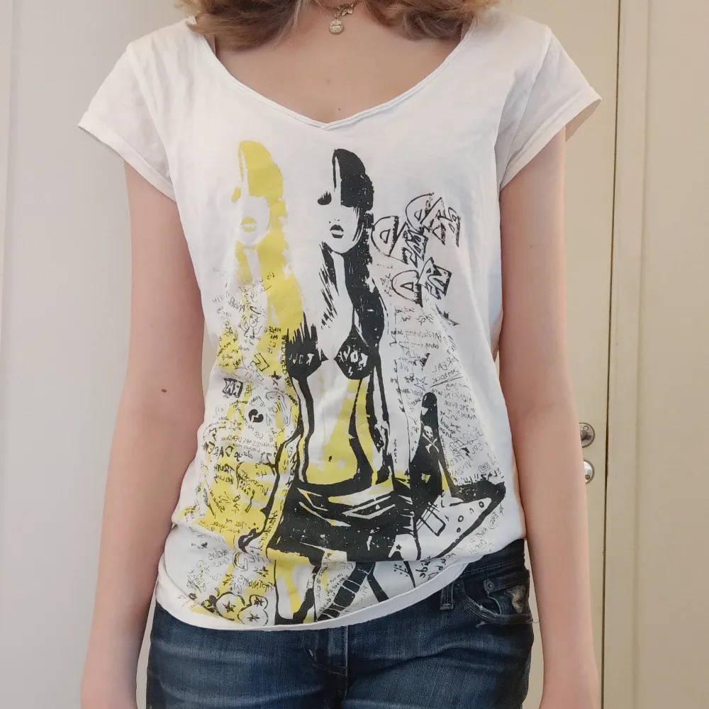 Säljer denna vita t-shirt med tjej som håller i gitarr tryck. Hör av er vid intresse 💘💘 TRYCK INTE PÅ KÖP NU. T-shirts.