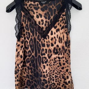 Leopard linne - Jättefint linne i lite blankt mareriel med svart spetskanr. Fint fall. Oanvänt. St S men passar likväl M. Samfraktar gärna med mina andra annonser.