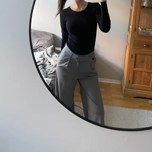 Gråa kostymbyxor - Så snygga gråa kostymbyxor från Zara med cool knäppning fram. Bra längd på mig som är 170cm lång😇