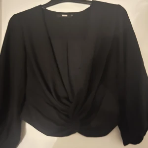 Svart urringad topp - Svart urringad blus/topp med trekvartsärm och lite ”ballongeffekt” från Bik Bok. Kan användas både fram och bak tycker jag! Kan behövas en nåbara framtill så man inte visar allt haha.