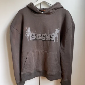 Seams Hoodie - En shyyst brun seams hoodie som släpptes på en av deras första drops med snyggt rhinestone motiv. Conditon är 8/10 då den har blivit solblekt på vissa ställen och säkert nån av stenarna har fallit av. Pris kan diskuteras och hör av er för fler bilder