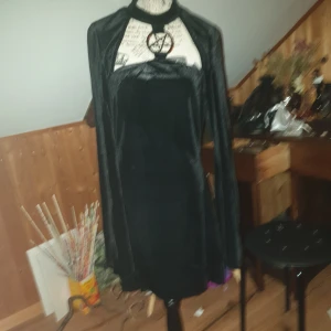 Gotisk klänning - Kort fräsig klänning med utsvängda ärmar samt pentagram över bysten, köpt för 699kr(Tror den är från Killstar, de säljer en likadan/liknande design.(andra bilden.) Köparen står för frakt, kan fixa fler bilder om så önskas😁 PRISFÖRSLAG GÅR BRA!
