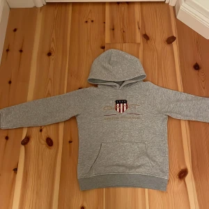 Grå gant hoddie  - Grå gant hoddie med guld logga änvänd för ett tag sen men bara i 1-2 månader jag har växt ut och den är inte min stil längre. Pris kan diskuteras 
