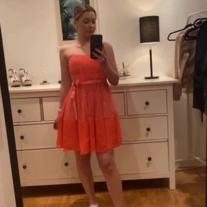 Klänning Bubbleroom - Korallfärgad klänning från Bubbleroom storlek 36-S. Snöret i midjan kan man ta bort och det finns en dragkedja på sidan av klänningen. Endast använd 1 gång vid skolavslutning.