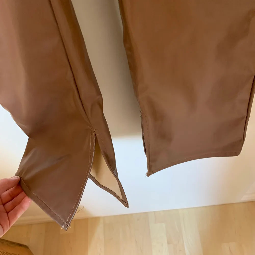 Så snygga bruna fejk läderbyxor från hm, med en slits längst ner. Oanvända. Jeans & Byxor.