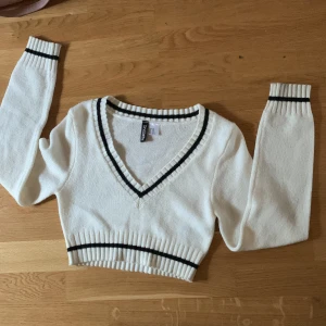 Långärmad stickad topp  - Säljer den här vita långärmade stickade toppen för att den börjar bli för liten. Svarat linjer lite här och där. 
