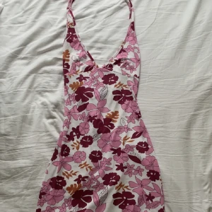 Blommig klänning - Blommig halterneck-klänning från SHEIN. Knyts i nacken och kan knytas på olika sätt. Använd vid ett tillfälle. Frakt ingår ej! 🌸(OBS! Tredje bilden är lånad.) Orginalpris: 89 kr.  Storlek S men är stretchig och passar därav allt mellan XS-M.