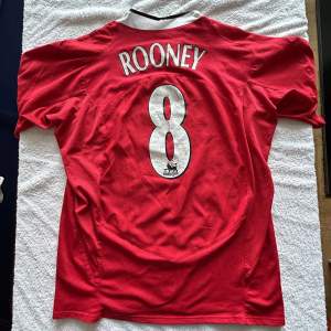 Manchester uniteds hemmatröja mellan 2004 och 2006, med legenden Wayne Rooney på ryggen, då han var nummer 8.  Storlek: S Skick: 7/10, Rooney trycket är lite skadat