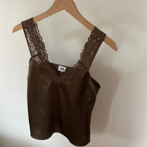 Meshlinne, mörkgrön, spets - Mörkgrönt meshlinne med spets detaljer. Lätt figursytt, passar bra under kavaj, till jeans, kostymbyxor. 