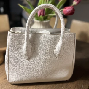 Beige handväska / axelväska  - Väska ifrån zara, mer beige i verkligheten. Jättefint skick. Aldrig använda. Tillkommer en rem så du kan ha den som en axelväska. Köpt för 599’kr 