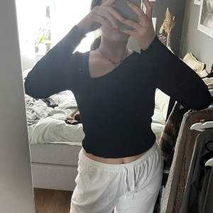 Ribbad topp - Svart ribbad lite tjockare topp med snedskuren hals. Superfin och jättebekväm! Väldigt lite använd. Står ingen storlek men jag är en S, dock väldigt stretchig så skulle uppskatta S-L!🫶🏻  Skriv vid fler bilder eller intresse!