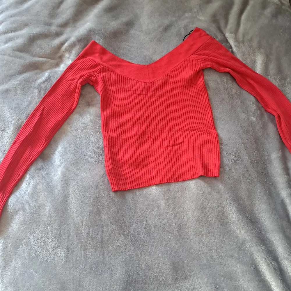 En röd långärmad tröja med ränder jag har änvänt den runt 4 gånger men den är tvättad. De är inget som är sönder.. Toppar.