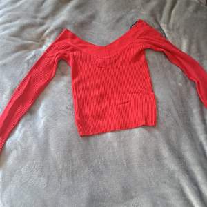En röd långärmad tröja med ränder jag har änvänt den runt 4 gånger men den är tvättad. De är inget som är sönder.