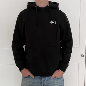 Stüssy Hoodie - Säljer denna Stüssy Hoodie då den är för liten och inte används. Jag är 183 cm och bär storlek S på bilden. Den är använd men ändå i väldigt bra skick! Inga hål eller slitningar! Nypris 1500 kr😁