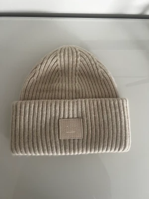 Acne mössa - Säljer min fina mössa från acne i beige. Köpt på acnes butik förra vintern. Älskar den men vill köpa en svart istället! 