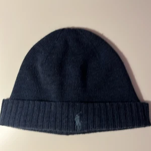 Ralph Laurent mössa  - Mörk blå mössa med blått märke  Skick: 8/10