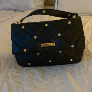 Väska - Säljer min söta väska med guldiga typ nitar 💓 medföljer ett guldig kedja! Vet inte vart den är ifrån fick den i present 