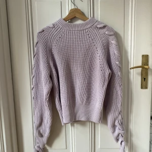 Stickade tröja H&M - Så mysig stickad ljusrosa/lila tröja från H&M men fina knytdetaljer på ärmarna! Nyskick! 💞💞
