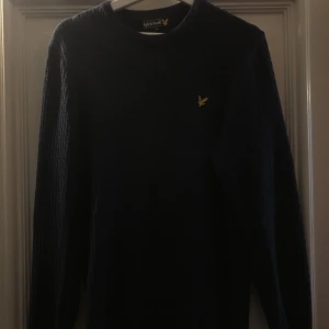Lyle & Scott tröja  - Säljer nu denna stickade Lyle & Scott tröjan i en marin blå färg som är parfekt inför vintern. Varan är i ett helt OK skick. Inga hål men defekter som en fläck förekommer. Den är i storlek M. Skriv vid fler funderingar! 