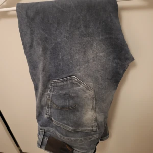 G-star jeans - Ett par snygga Herrjeans ifrån G-star. Jeansen är hela och inga missfärgningar förekommer förutom Gstar tagen på baksidan som håller på att lossna. Jeansen är I storleken: W 33 L 32
