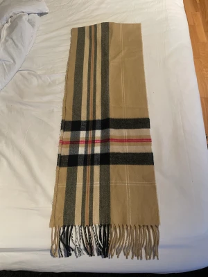 Burberry halsduk  - Säljer en burberry halsduk i väldigt fint skick. Använd ett par gånger men inga slitage eller märken alls. 
