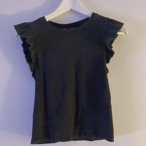 Grå topp med volang  - Grå ribbad topp från zara med volang på ärmarna  Bra skick